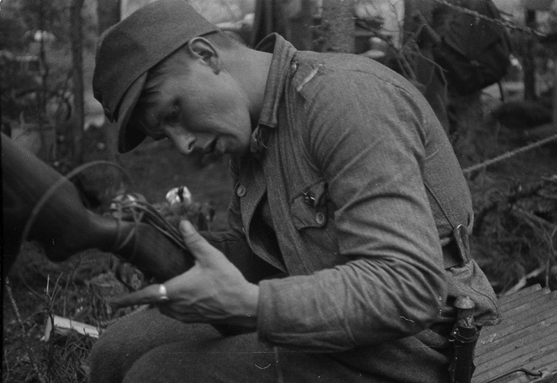 Капрал финской армии с помощью подручных средств ремонтирует трофейный советский пистолет-пулемет ППД-34