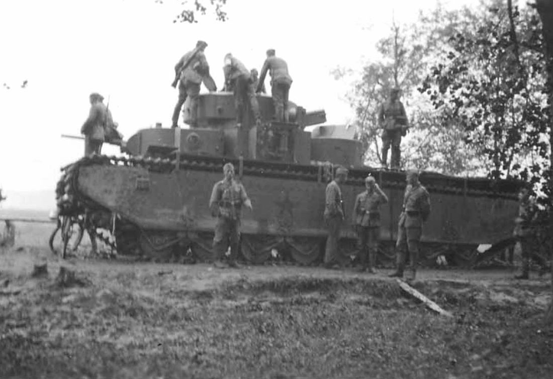 Немецкие солдаты осматривают советский танк Т-35 брошенный на трассе в 5 км. от г.Сасов