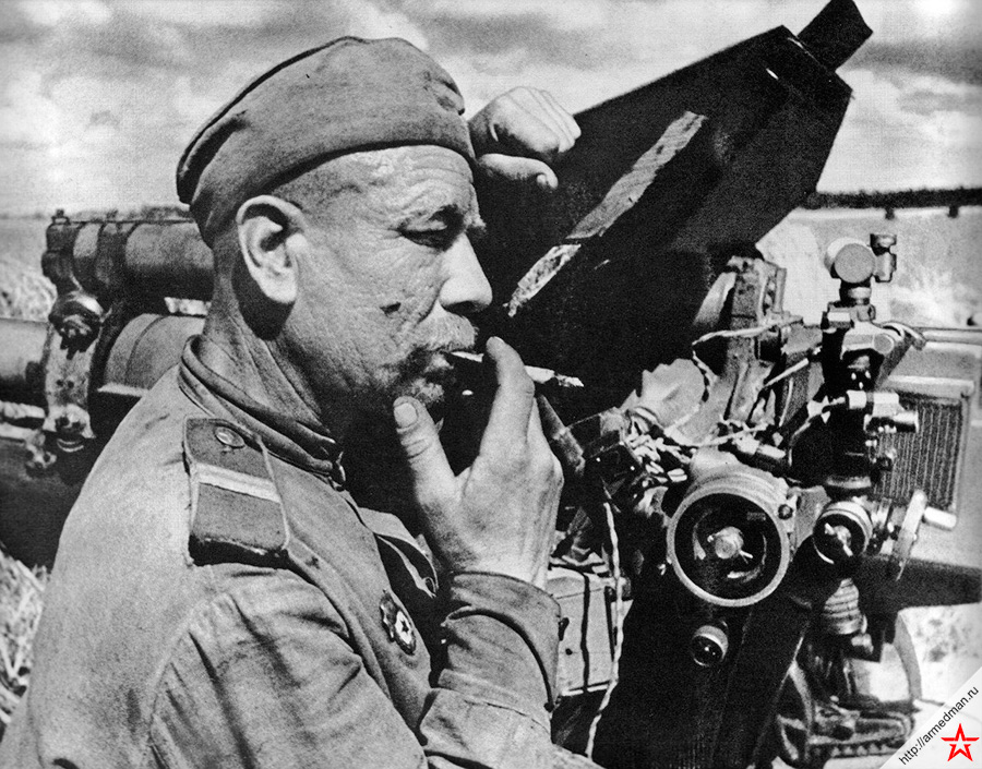 Советский артиллерист-гвардеец отдыхает у своей 122-мм гаубицы М-30 после боя с немецкими танками под Каунасом. 3-й Белорусский фронт. Осень 1944 года