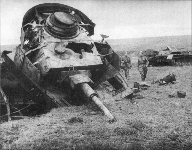 Советские бойцы рассматривают разбитый немецкий танк Pz.Kpfw. IV Ausf. Н (одностворчатый люк и отсутствие на башне трехствольных гранатометов). Танк окрашен в трехцветный камуфляж. Орловско-Курское направление.