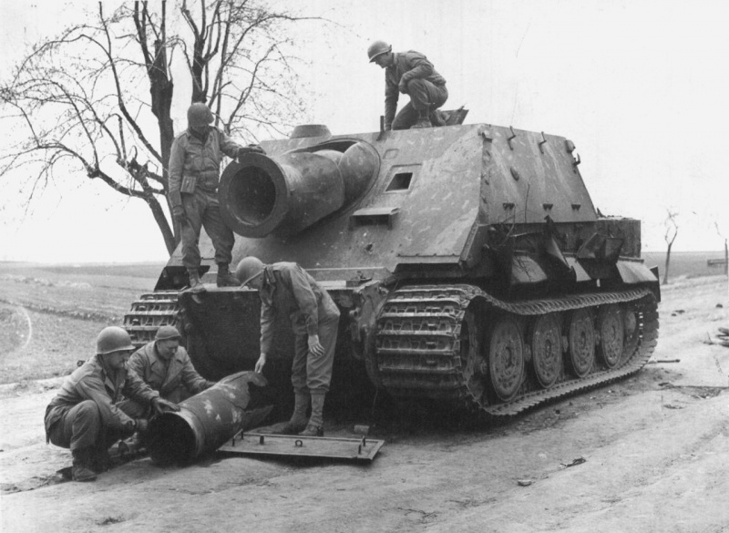 Военнослужащие 9-й армии США осматривают немецкую САУ «Штурмтигр» (Sturmtiger), захваченную в районе Миндена (Minden), Германия.