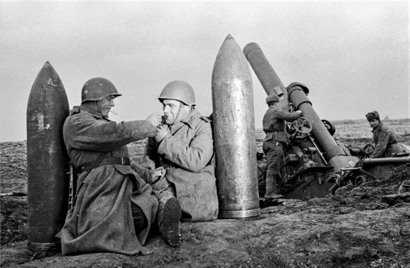 Красноармейцы-артиллеристы расчета 280-мм мортиры образца 1939 года Бр-5 отдыхают у снарядов.