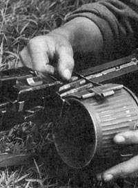 Заряжание единого пулемета MG.34 металлической патронной лентой с незамкнутыми звеньями Gurt 34