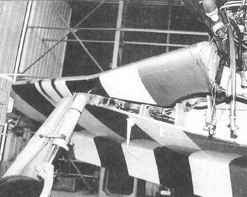 Правая стойка шасси P-51D. Видна колесная ниша. На переднем плане трубопроводы двигателя.