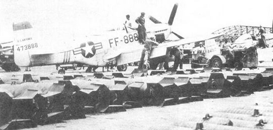 Механики подвешивают бомбы под «Мустанг» командира 39-й эскадрильи. На переднем плане видны уложенные бомбы.