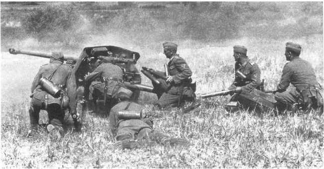 Расчет 50-мм противотанковой пушки Pak 38 во время боя. Лето 1941 года, советско-германский фронт. Хорошо видно расположение командира, наводчика, заряжающего и двух подносчиков выстрелов. У казенника видна гильза, экстрактирующаяся после выстрела (АСКМ).