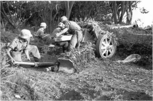 Расчет 75-мм противотанковой пушки Pak 40 ведет бой. Италия, 1943 год. Крайний слева номер расчета достает 75-мм выстрел из пенала-укупорки (ЯМ).