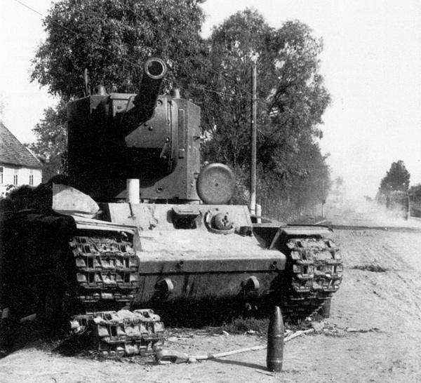 Танк КВ-2 из состава 3-й танковой дивизии 1-го мехкорпуса, подбитый в бою за Остров 5 июля 1941 года. Судя по видимым повреждениям и актам на списание, это танк № Б-4754. На броне машины видны многочисленные следы попаданий снарядов (АСКМ).