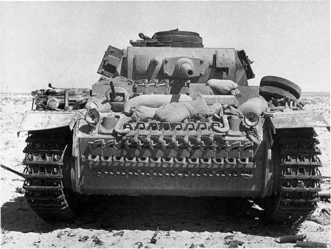 Танк Pz.III Ausf.J перед боем. Лобовая броня машины усилена не только запасными траками гусениц, но и мешками с песком. Северная Африка, 1941 год.