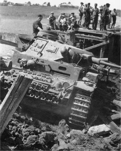 Не все мосты в России выдерживали 20-тонный танк. Экипажу этого Pz.III Ausf.F из состава 13-й танковой дивизии придется повозиться, вытаскивая свой танк. Восточный фронт, лето 1941 года.