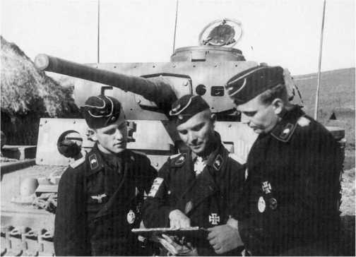 Один из наиболее известных немецких танкистов периода Второй мировой войны — командир 2-го батальона 11-го танкового полка 6-й танковой дивизии майор Беке (в центре) дает последние указания подчиненным перед атакой. На заднем плане — командирский танк Pz.Bf.Wg.III Ausf.К. Курская дуга, июль 1943 года.