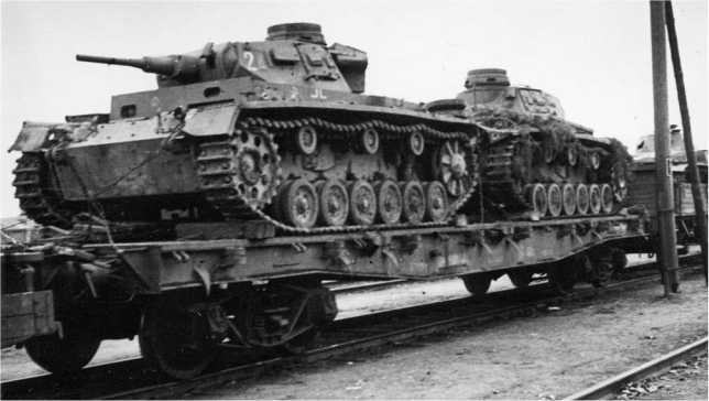 Эшелон с трофейными танками направляется в тыл. Рядом на платформе два танка Pz.III Ausf.G. Западный фронт, 1942 год.