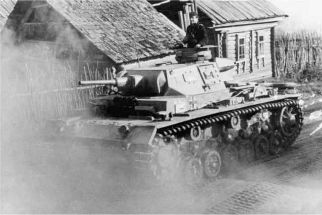 Pz.III Ausf.J проезжает по улице русской деревни. Восточный фронт, 1942 год.