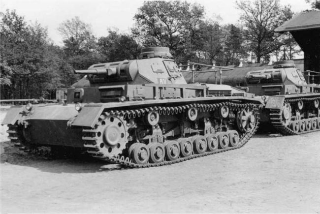 Командирские танки Pz.Bf.Wg.III Ausf.D1. Судя по номерам, это машины командира полка (R01) и его адъютанта (R02). Так как кресты на танках отсутствуют, то можно предположить, что снимок сделан в одной из частей Вермахта незадолго до начала войны.