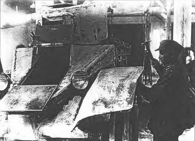 Монтаж левого переднего подкрылка на опытный танк БТ-2-ИС выполняет слесарь- ударник Анисифоров.