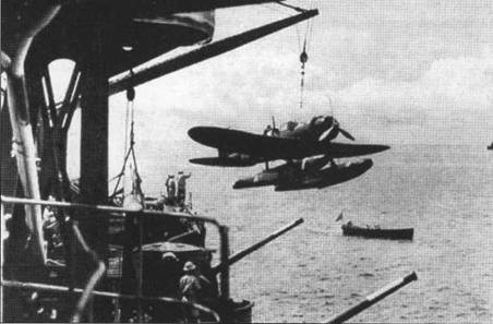Подъем гидросамолета Аичи E13A1 тип 0 на борт тяжелого крейсера «Аоба», снимок 1943 г. На переднем плане — стволы двух 120-мм зенитных орудий тип 10.