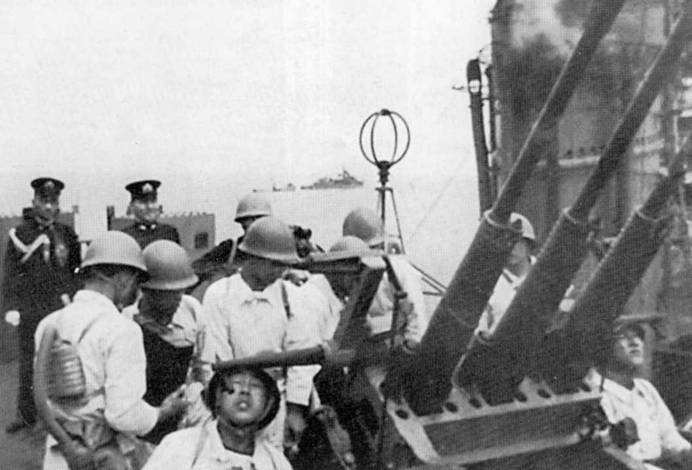 Учения артиллерийского расчета строенной 25-мм автоматической зенитной пушки, легкий крейсер «Оёдо», конец 1944 г. В центре фотографии — рамочная антенна радиопеленгатора.