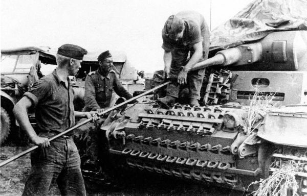 Экипаж танка Pz.III Ausf.F 16-й <a href='https://arsenal-info.ru/b/book/1627328415/38' target='_self'>танковой дивизии</a> за чисткой орудия. 1941 год. Машина прошла значительную модернизацию, в ходе которой на ней установлена 50-мм пушка, усилено бронирование лобового листа подбашенной коробки и верхнего и нижнего лобовых листов корпуса. Несмотря на это, экипаж, где только можно, навесил на машину гусеничные траки.