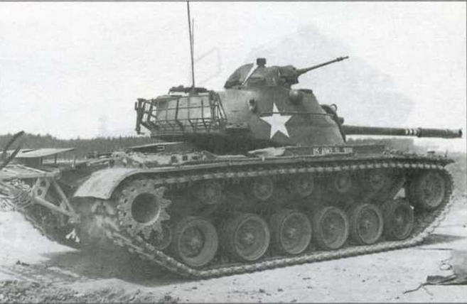 Танк М48А1 во время боевых стрельб на территории Германии. Обращают на себя внимание командирская башенка М1, дополнительный каток в ходовой части, платформа для крепления бочек с топливом и башенная корзина для амуниции