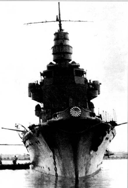 Легкий крейсер типа «Нака», вид с носа. Снимок Датирован 22 апреля 1942 г. Ракурс наглядно демонстрирует сколь узкими были корпуса японских легких крейсеров. К правому борту пришвартована баржа, с которой на крейсер перегружают запасы. Отлично видна императорская Хризантема.