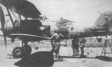 Механики поднят этот «Гладиатор Mk I» (L7619) из 112-й эскадрильи для ремонта, Судан, начало 1941 года. Бортовые панели сняты. Окраска самолета серьезно повреждена солнцем и песком.