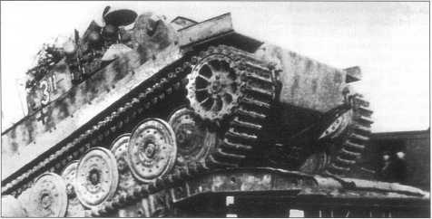 Pz.Kpfw.VI(H), оснащенный транспортными гусеницами, грузится на платформу. Франция, конец апреля 1944 года.