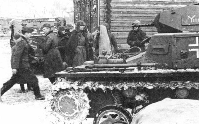 Pz.Kpwf.l из 7-го танкового полка 10-й бронетанковой дивизии. Слева — группа пленных советских солдат и немецкая штабная машина. Восточный фронт, зима 1941–1942 гг.