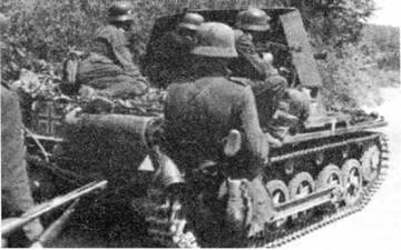 Немецкие пехотинцы продвигаются по дороге под прикрытием «истребителя танков» Panzerjager IB. Франция, 1940 г.
