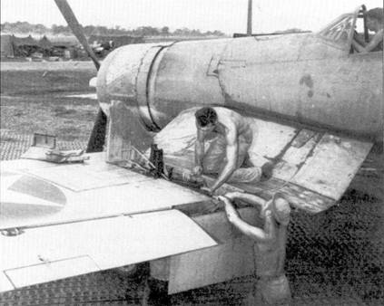 Оружейники снаряжают патронные ящики трех «Браунингов» левой плоскости крыла «Корсара», Гуадалканал. Самолет принадлежит или эскадрилье VMF-213, или VMF-124.