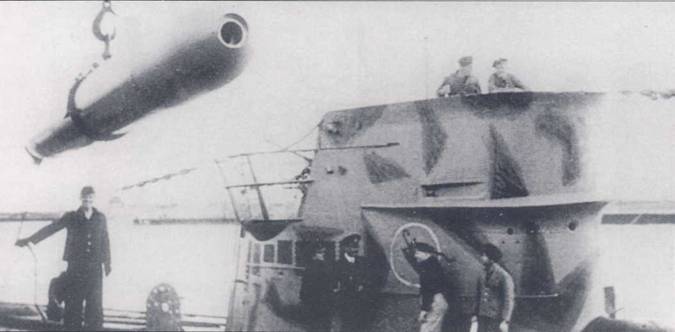Погрузка торпеды на субмарину U-40. Погрузка торпед производилась без взрывателей. Процесс погрузки был растянут во времени и отличался трудоемкостью в силу значительной массы торпед и тесноты внутри корпуса лодки. Рубка необычно камуфлирована геометрическими пятнами темно-серого цвета. Сама лодка — светло-серая.