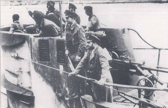 Рубка субмарины U-109 типа IXB. Моряки смотрят как их корабль ставят к стенке пирса. У-бот вернулся из дальнего плавания. Просматривается разрушающий. светло-темно-серый камуфляж рубки. На рубочной платформе установлен 20-мм зенитный автомат. Лодкой U-109 командовал корветтенкапитан Ганс-Георг Фишер.
