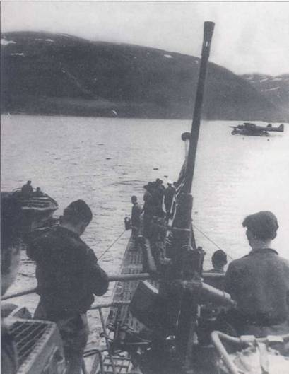 U-703 типа VIIC, лодкой командовал капитан-лейтенант Гейнц Бифельд. Субмарина вышла в точку рандеву с гидропланом Bv-I38C–I/UI, вероятно из 1(F) SAGr-130, действовавшей из Тронхейма. Гидросамолеты использовались для доставки на субмарины приказов, почты и др. Рандеву лодок и самолетов, как правило, назначали в норвежских фьордах. На переднем плане — 20-мм зенитка С/30.