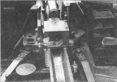 Казенная часть 105-мм гаубицы крупным планом. Хорошо видны клиновой затвор, лафет и сиденья членов орудийного расчета.