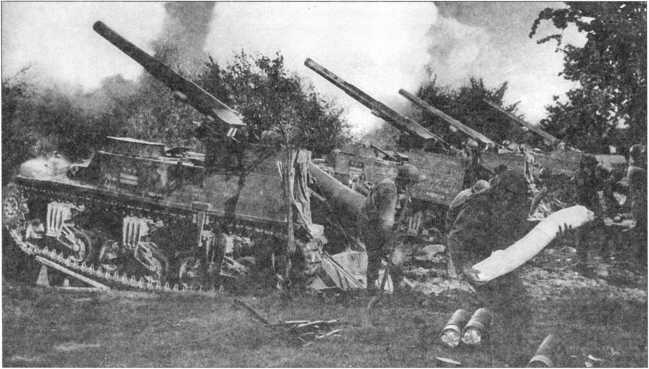 Батарея М12 из 991-го батальона полевой артиллерии ведет огонь. Район Аахена, Германия, сентябрь 1944 года. На переднем плане солдат с картузным зарядом в руках.