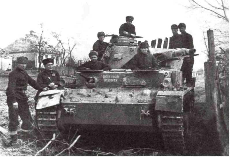 Бойцы Красной Армии на трофейном танке Pz. IV. Северо-Кавказский фронт, весна 1943 года. На лобовом листе машины видна надпись «весенний подарок» (МС).