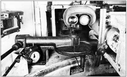 Место наводчика танка «Тигр». На переднем плане — механизм ручного привода поворота башни, над ним — окуляры бинокулярного прицела TZF-9а.