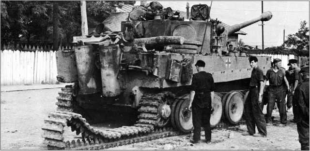 Демонтаж транспортной гусеницы с одного из танков «Тигр» моторизованной дивизии «Великая Германия». Август 1944 года.