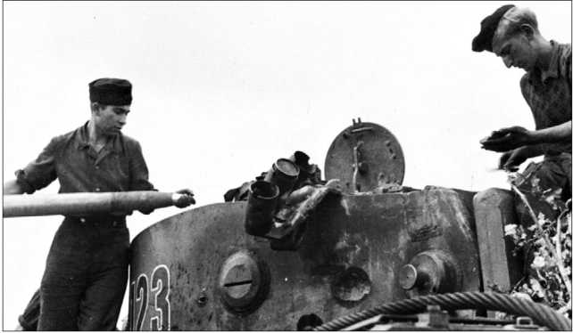 Загрузка боеприпасов в один из танков 503-го тяжелого танкового батальона. Хорошо видна вмятина от снаряда в борту башни.