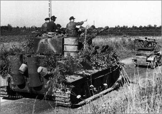 Один из танков 102-го тяжелого танкового батальона СС выдвигается к линии фронта у реки Орн. Нормандия, июль 1944 года.