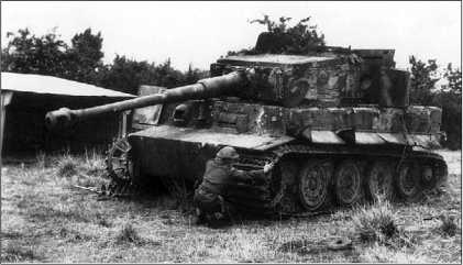 Английский солдат осматривает подбитый «Тигр» из 102-го тяжелого танкового батальона СС. Август 1944 года.