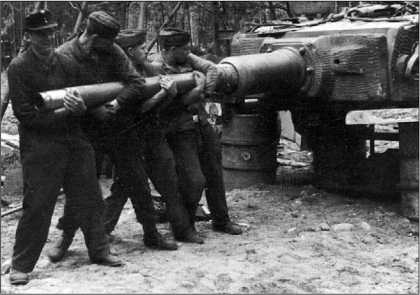 У этого «Тигра», по-видимому, неисправен накатник. Ремонтники пытаются вернуть ствол пушки в положение, соответствующее концу наката. 1944 год.