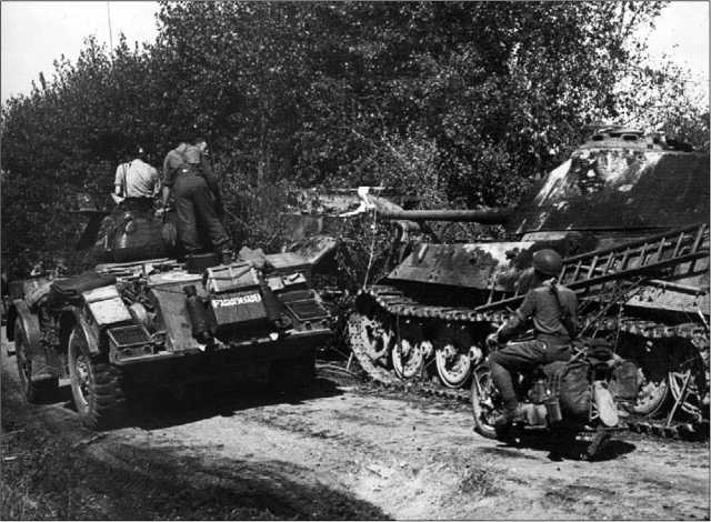 Канадские солдаты проезжают мимо брошенных на обочине дороги БРЭМ «Бергепантера» и буксировавшегося ею «Королевского тигра». Обе машины из 503-го тяжелого танкового батальона. Нормандия, август 1944 года.
