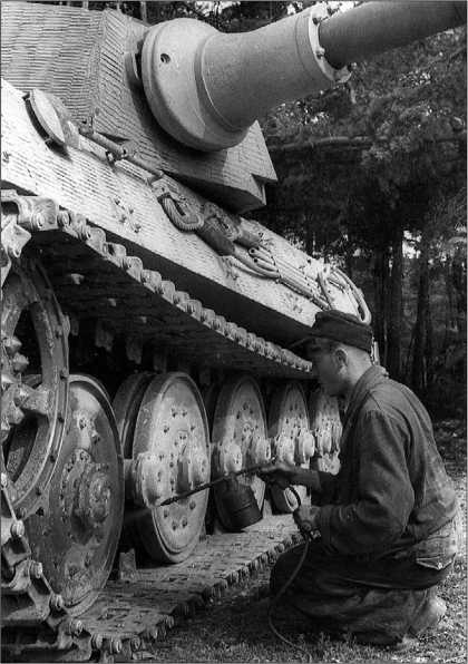 Экипажи 501-го тяжелого танкового батальона наносят камуфляжную окраску на свои «королевские тигры». Франция. 1944 год.