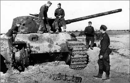 Красноармейцы осматривают тяжелый танк «Тигр-Б», подбитый на Сандомирском плацдарме. Судя по многочисленным вмятинам, пробоинам и отсутствию кормовых листов башни, этот танк подвергся обстрелу из различных артсистем с целью выяснения его поражаемости. Польша, август 1944 года.