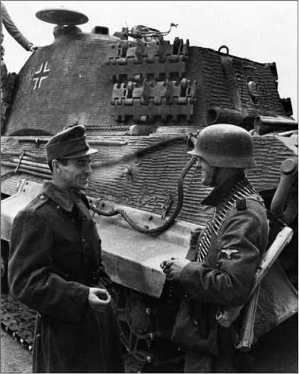 Товарищи по оружию: солдат войск СС беседует с венгерским гонведом, стоя рядом с «Королевским тигром». Будапешт, осень 1944 года.