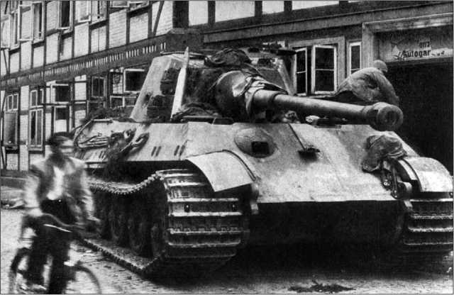 «Королевский тигр» из состава 507-го тяжелого танкового батальона у дверей отеля «Кайзерхоф» в городке Остероде. Германия, апрель 1945 года. В правом борту башни отчетливо видна пробоина от снаряда.