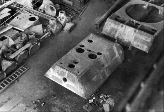 Сборочный цех завода Krupp в Эссене. Хорошо видны корпус и башня «Мауса», а также две литые маски спаренной установки 128-мм и 75-мм пушек. Май 1945 года.