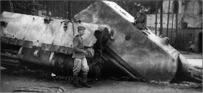 Красноармейцы осматривают взорванный танк «Маус» 205/2. Июнь 1945 года. На переднем плане — кусок гигантской гусеницы этого танка.