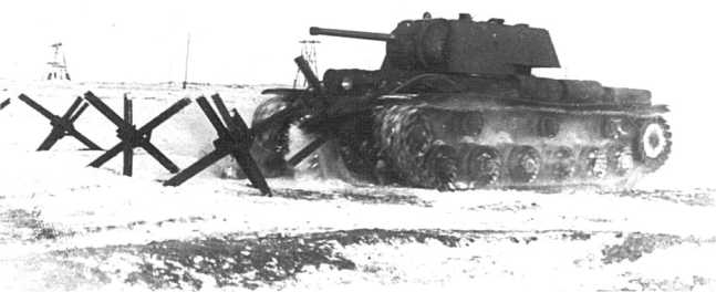 Танк КВ-1 (№ 10033) с форсированным двигателем, измененным передаточным числом бортредуктора и количеством зубцов на ведущем колесе преодолевает заграждение из противотанковых «ежей». Февраль 1942 года (ЦАМО).