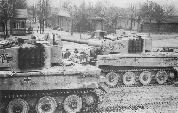 «Тигры» после перевозки по железной дороге — у танков демонтированы наружные катки и надеты узкие транспортные гусеницы. Размещение запасных траков на бортах башни практиковалось со второй половины 1943 года.